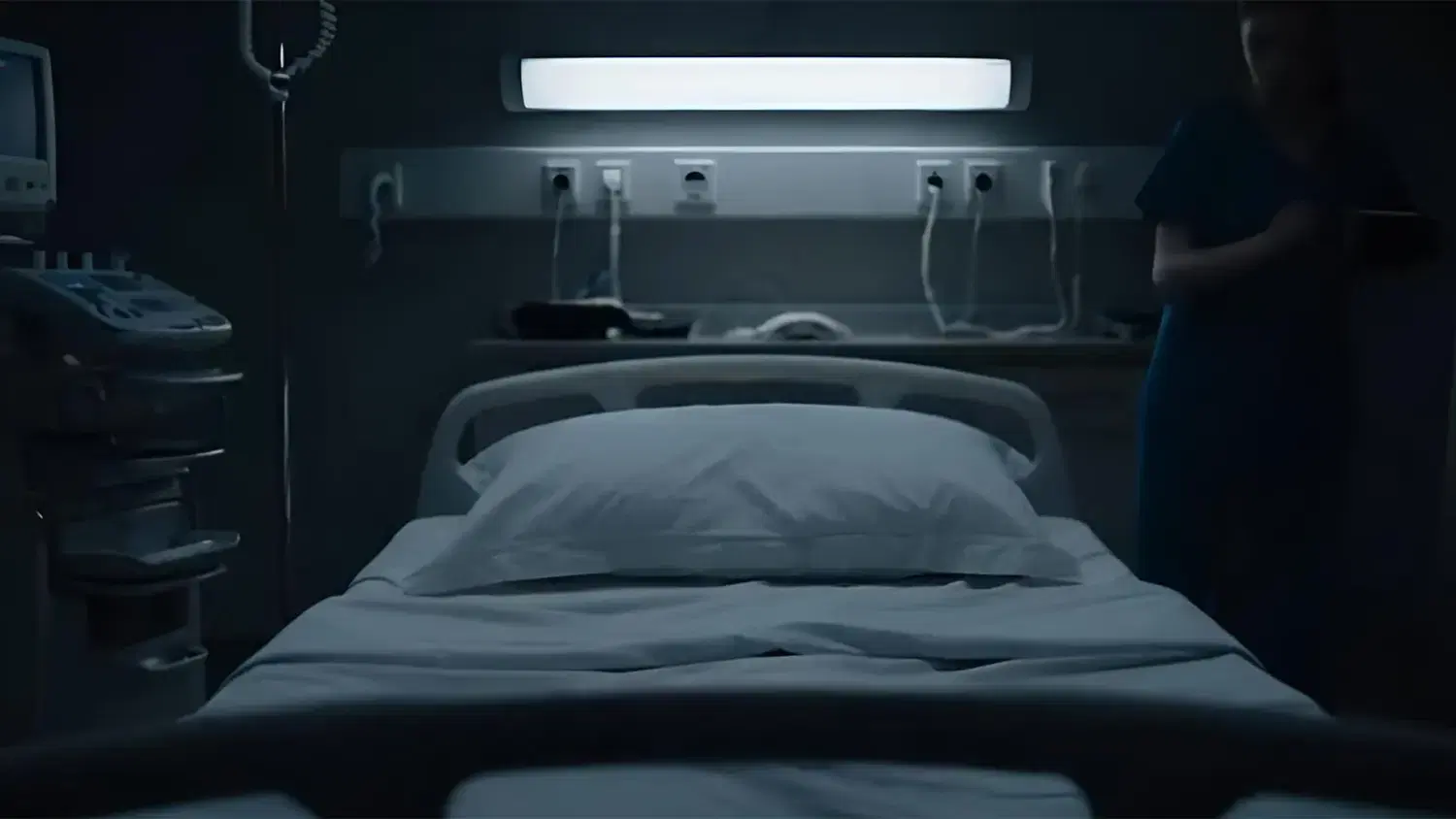 Nurse presenting a VR headset to an elderly patient in bed